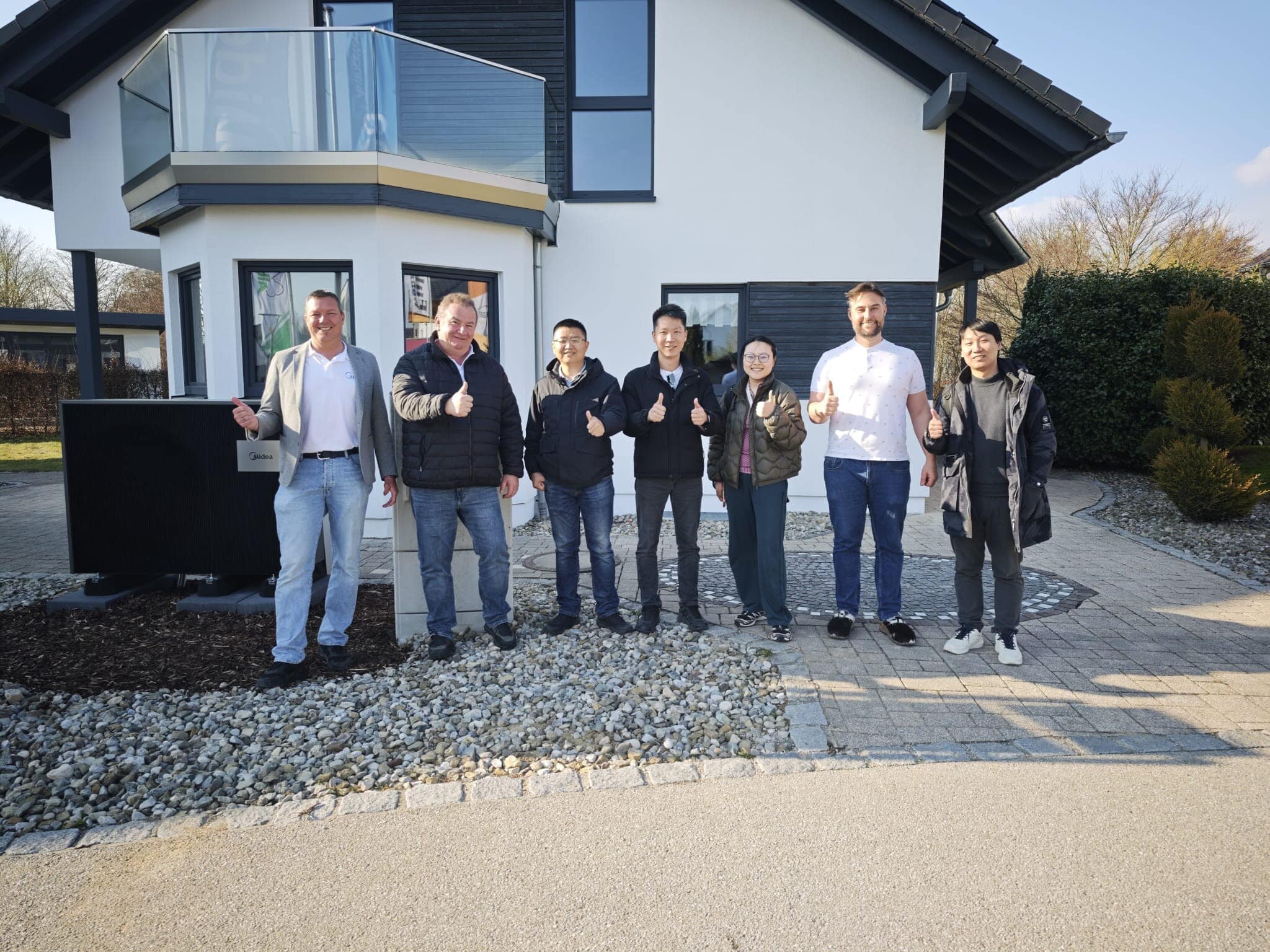 Avancetec Team mit Partnern vor einem Haus mit Wärmepumpe